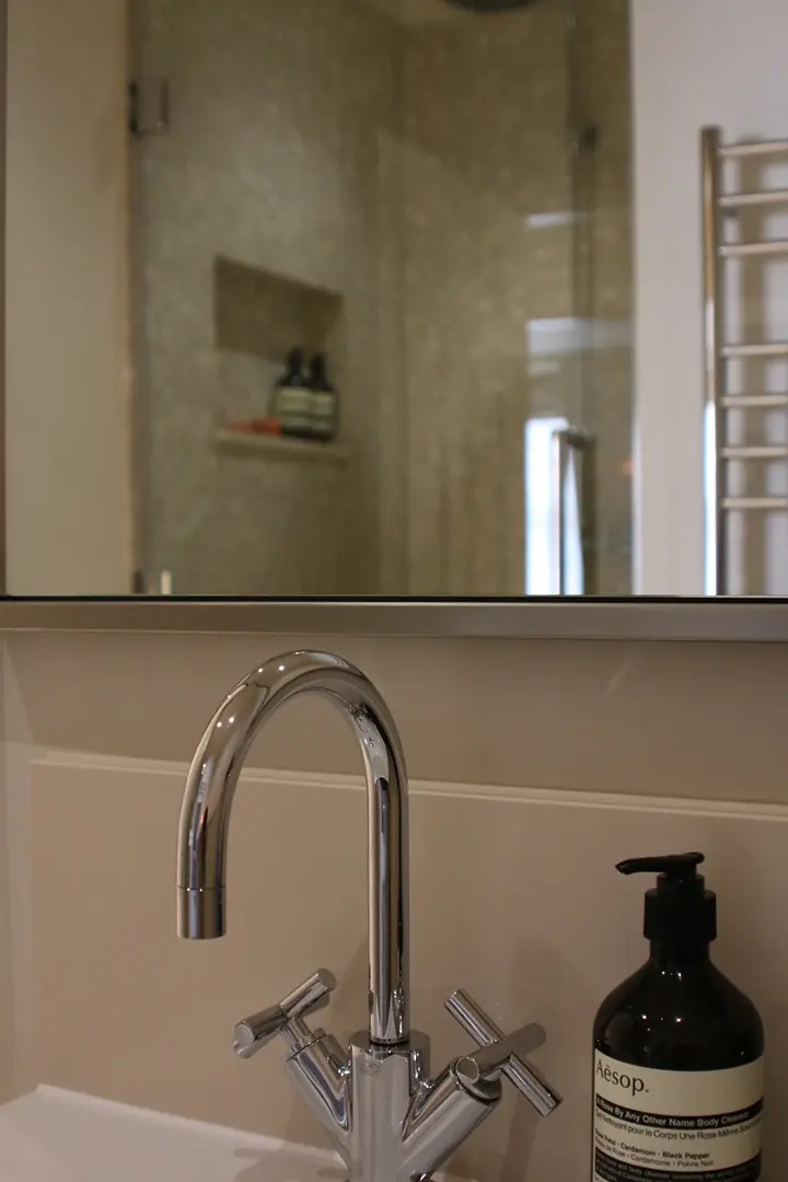 Bathroom brassware and mirrored cabinetry detail