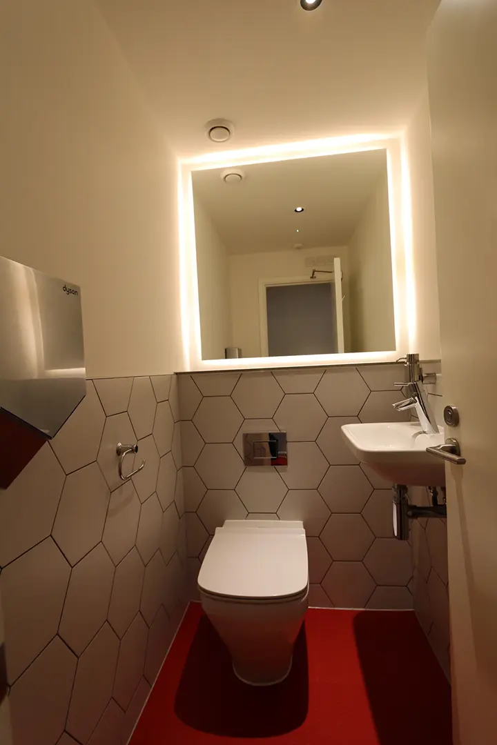 Compact restaurant washroom with illuminated mirror