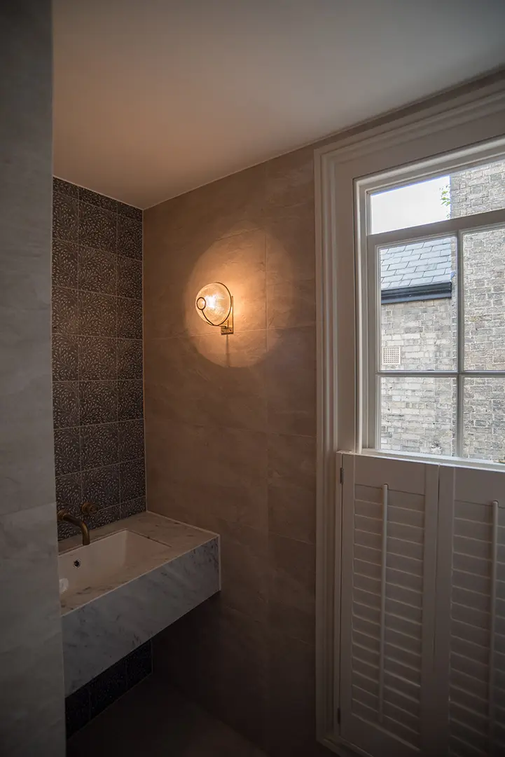 Restored reception room with dark bespoke cabinetry and soft architectural lighting