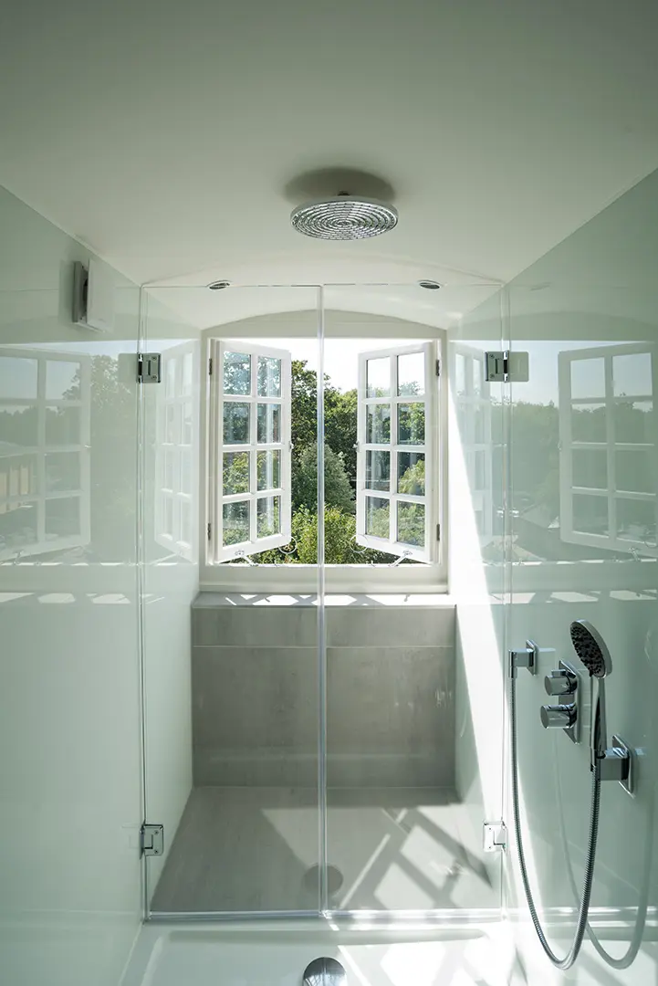 Panelled bathroom with a freestanding bath overlooking the garden